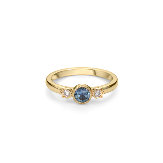 Yellow gold stackable ring with round beaded bezel set Montana blue sapphire and diamonds in flower setting on each side.