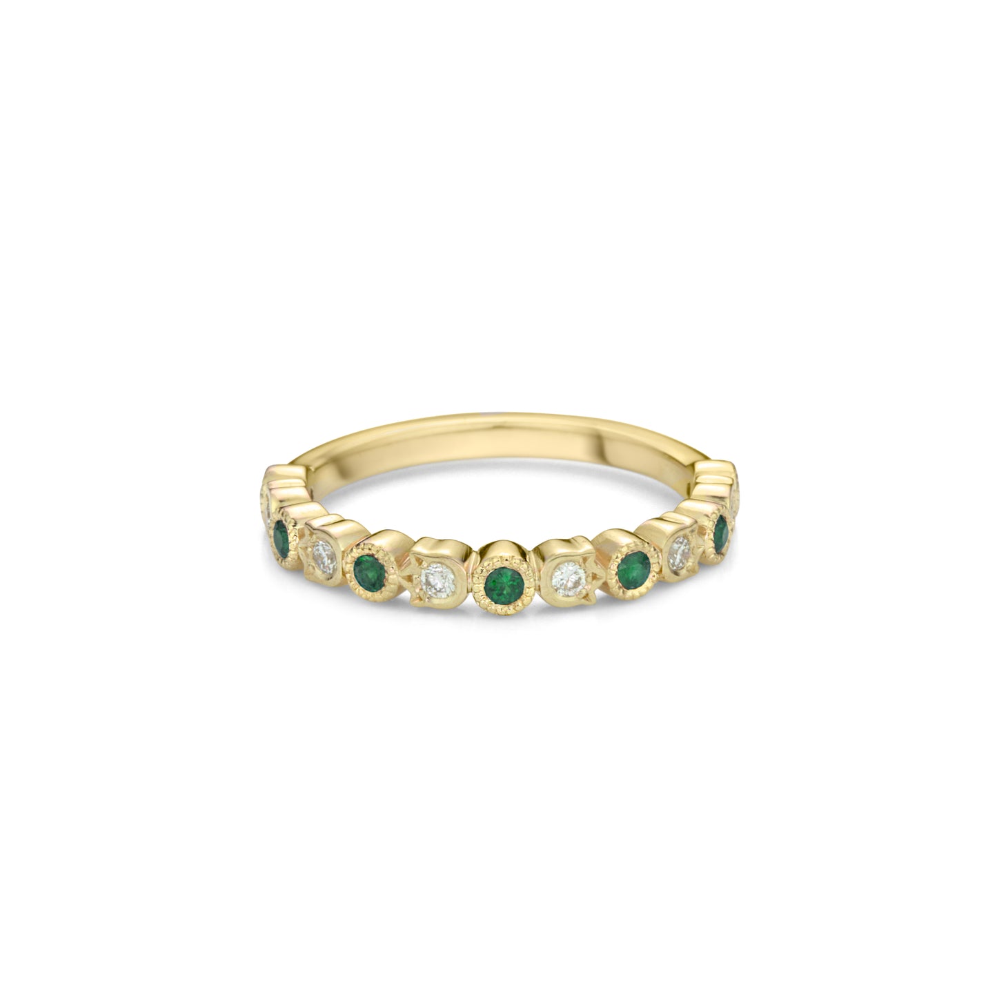 A yellow gold band style ring set half way with alternating emeralds in round bezels with millegrain and diamonds in flower shaped bezels.