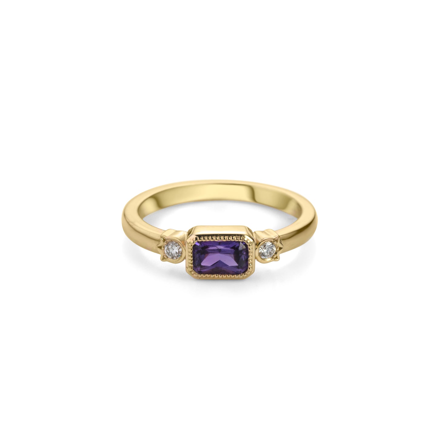 Yellow gold ring with horizontally set radiant cut royal purple sapphire in millegrained bezel and diamonds in flower shaped setting on each side.