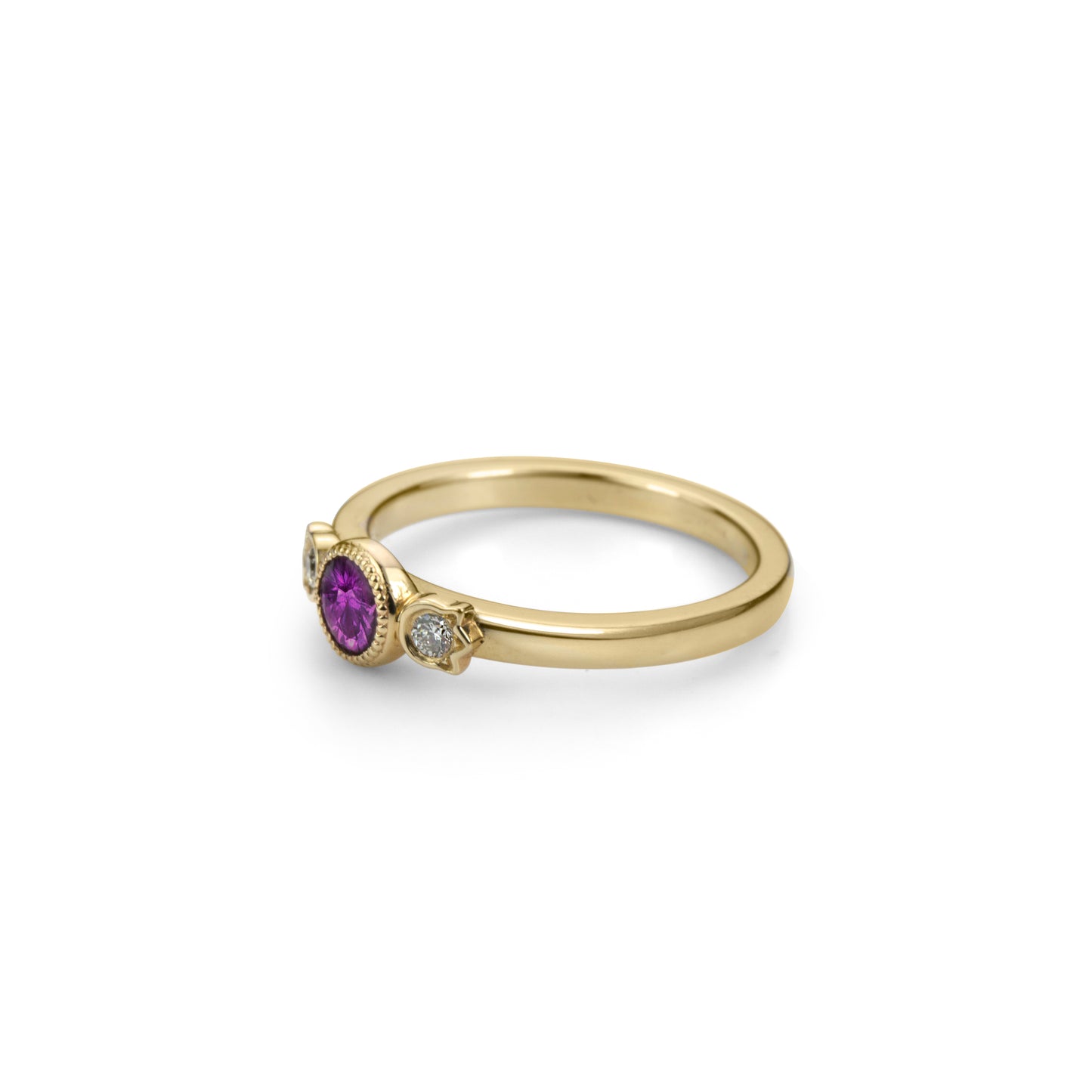 Yellow gold stackable ring with round beaded bezel set plum purple sapphire and diamonds in flower setting on each side in profile view.